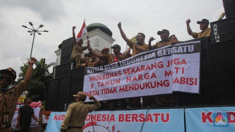 Sumber foto: CNBC Indonesia Kades demo di depan gedung DPR sambil memegang spanduk bertuliskan tuntutan jabatan 9 tahun