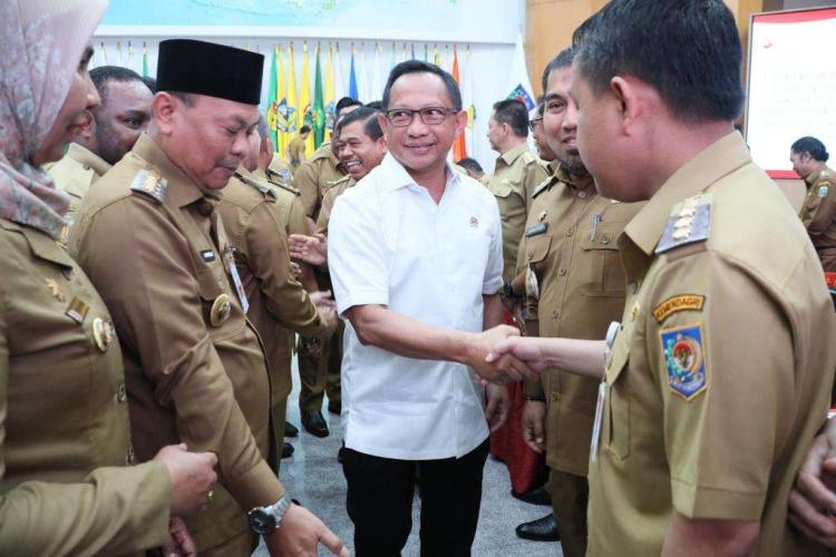 Tito Karnavian Berjabat Tangan dengan Pj Bupati Aceh Besar FOTO/DOK PEMKAB ACEH Foto Menteri Dalam Negeri Tito Karnavian Berjabat Tangan dengan Pj Bupati Aceh Besar Muhammad Iswanto SSTP MM, sembari dikelilingi sejumlah aparatur sipil negara pada Rakor Penjabat Kepala Daerah dalam Rangka Menjamin Peningkatan Kesinambungan Penyelenggaraan Pemerintahan Daerah dan Pelayanan Publik serta Implementasi Kebijakan Strategis Nasional di Daerah, di Gedung Sasana Bhakti Praja, Kantor Pusat Kemendagri, Jakarta