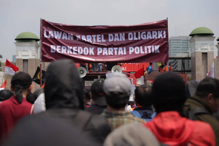 Foto: Jamal Ramadhan/kumparan peserta aksi 22 Agustus 2024 membentangkan banner di depan gedung DPR dengan tulisan "Lawan Kartel dan Oligarki Berkedok Partai Politik"