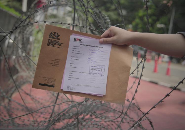 Gambar surat terima pengiriman surat dari KPK yang dipegang di tengah kawat berduri
